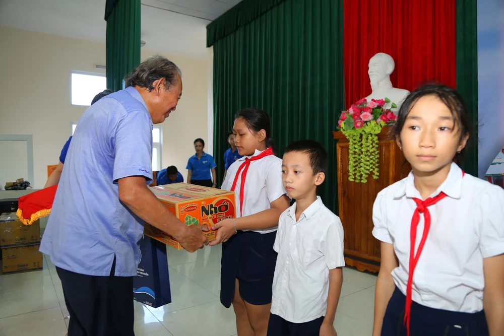 Nguyên Phó Thủ tướng thường trực Chính phủ Trương Hòa Bình tặng quà cho các con em của bà con ngư dân. Ảnh: HOÀNG GIANG