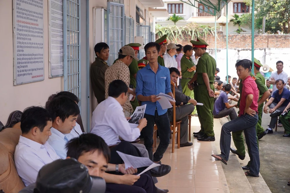 Cán bộ tòa án (áo xanh) đi gom lại bài báo của báo Pháp Luật TP.HCM để trình cho chủ tọa. Ảnh: NGÂN NGA