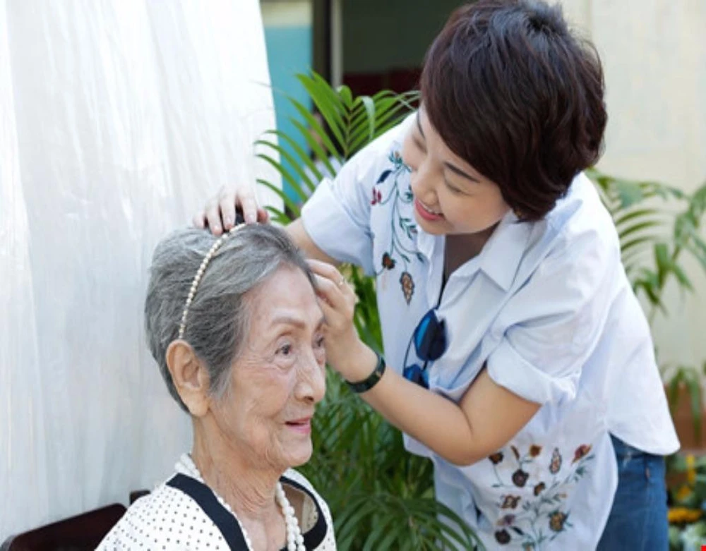 Một cụ bà tại Viện dưỡng lão Thị Nghè đang được trang điểm trước khi trình diễn thời trang.