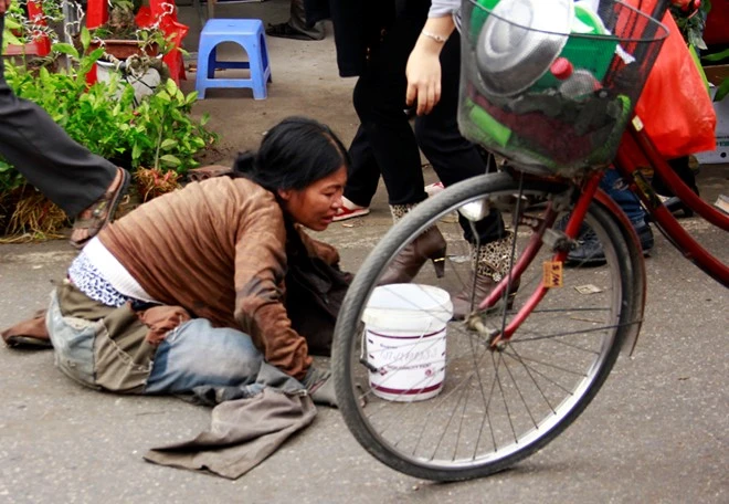 Một phụ nữ bò ra đường để lấy được sự thương cảm của du khách.