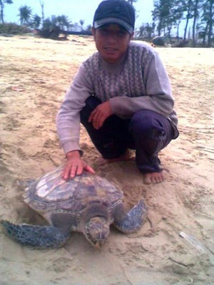 Ngư dân Hồ Văn Năm với cá thể rùa kỳ lạ.
