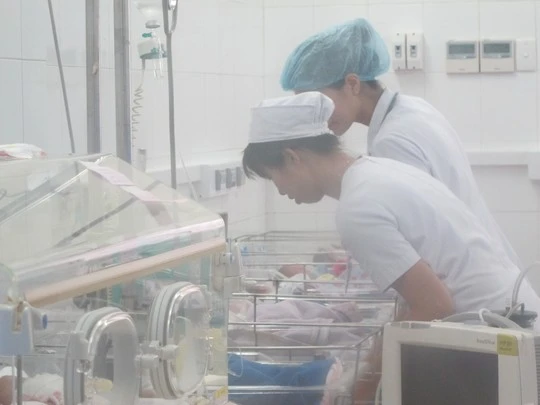 Các điều dưỡng đang chăm sóc bé trai, con sản phụ đẻ rơi.