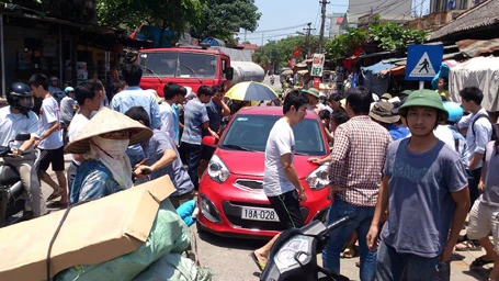 Chiếc xe ô tô bị người dân quây kín.