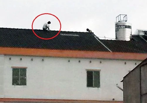 Tên trộm cố thủ trên nóc nhà, dọ sẽ nhảy xuống tự tự nếu ai đó tiếp cận bắt. Ảnh:Độc giả cung cấp Tên trộm cố thủ trên nóc nhà, dọ sẽ nhảy xuống tự tự nếu ai đó tiếp cận bắt. Ảnh: Độc giả cung cấp