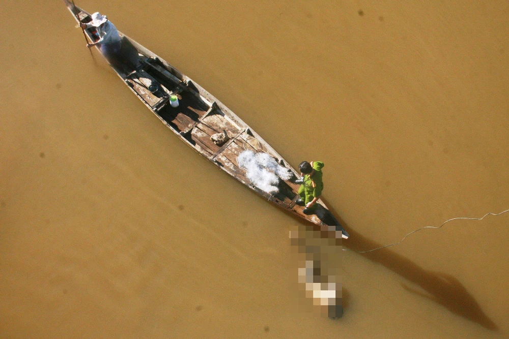 Cơ quan chức năng đưa thi thể nạn nhân lên bờ để tiến hành điều tra