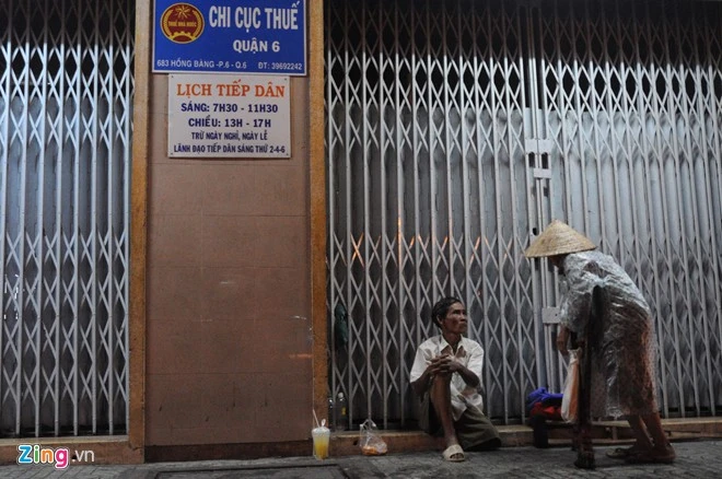 Những người cùng cảnh ngộ. Hai ông bà bán vé số dạo đang trú mưa tại đường Hồng Bàng (quận 6).