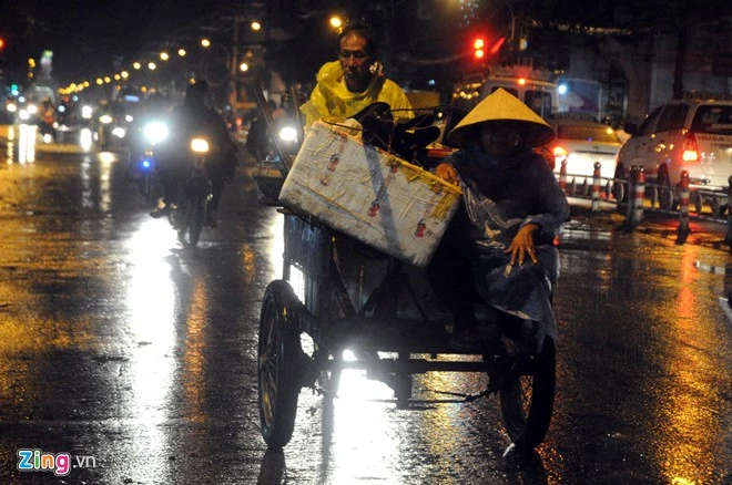Hai vợ chồng xe ba gác đi dưới mưa trên đường 3 tháng 2 (quận 10).