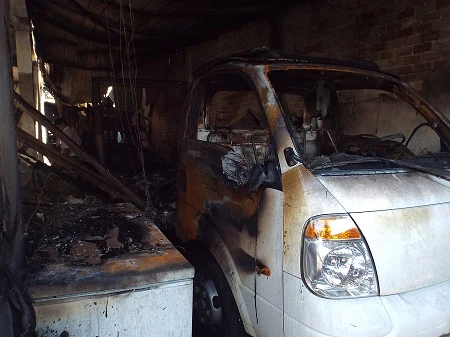 2 chiếc xe ô tô tải (dùng để vận chuyển kem) đang đỗ trong khu vực nhà xưởng bị bị chay rụi.