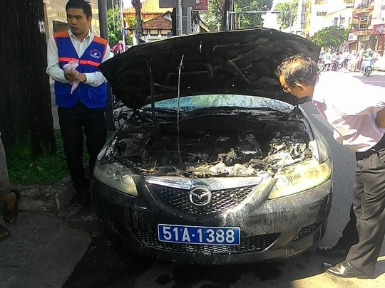 Thợ bảo trì đang xem máy móc trước đầu xe cháy đen.