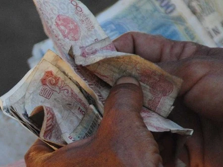 Những đồng tiền lẻ trong bàn tay một người lao động.