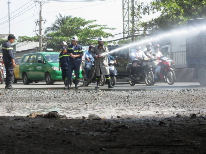 Lực lượng chức năng phun nước rửa hóa chất - Ảnh: Hải Hiếu