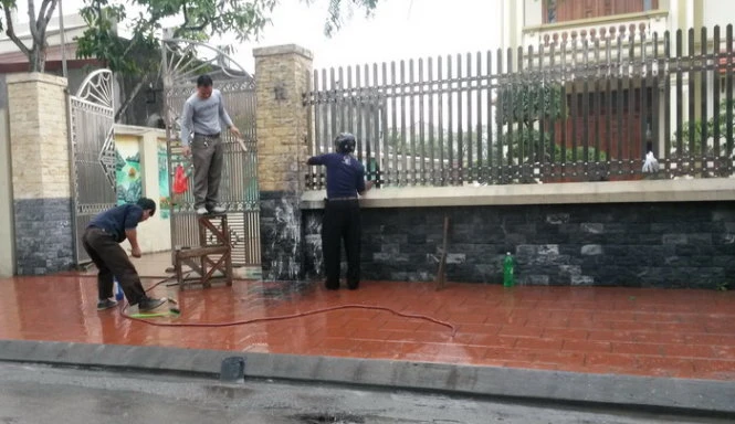 Người dân đang tẩy rửa khu vực thi thể bị đốt cháy - Ảnh: Thân Hoàng