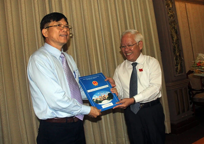 Chủ tịch UBND TP Lê Hoàng Quân trao quyết định bổ nhiệm giám đốc Học viện Cán bộ TP cho phó giáo sư-tiến sĩ Nguyễn Văn Trình - Ảnh: Quang Khải