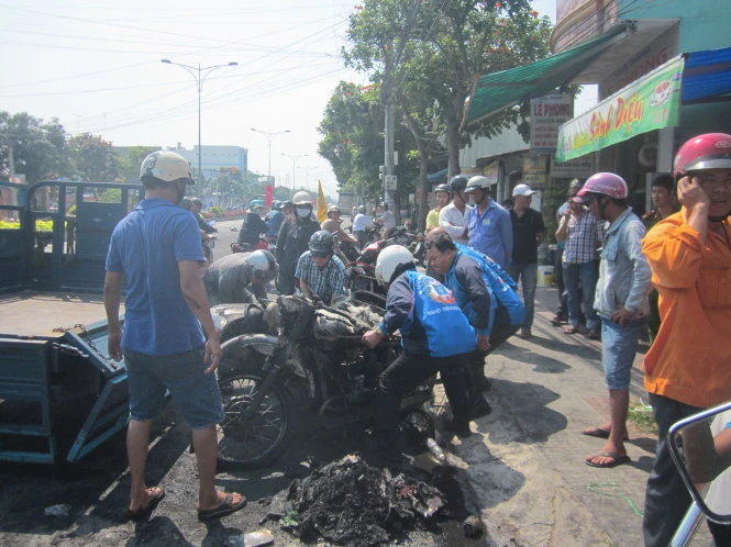 Người dân đưa chiếc mô tô bị cháy rời khỏi hiện trường