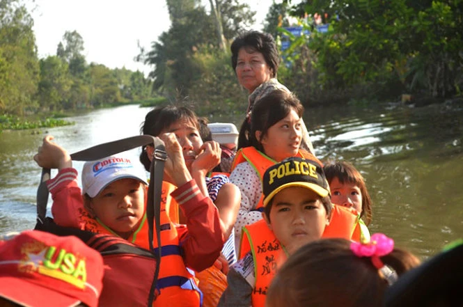 Bà Bảy trên chuyến vỏ lãi đưa các em đến trường - Ảnh: M.Tâm