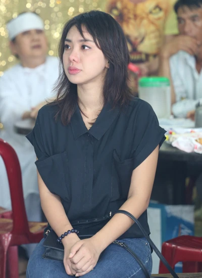 Ca sĩ Lan Trinh ngồi im lặng một góc, mắt hướng về di ảnh người quá cố.