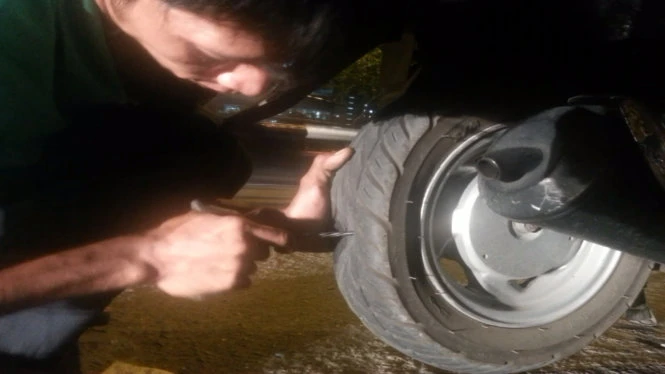 Thợ sửa xe “ra tay”, chiếc lốp không ruột đang lành lặn bị thủng ba lỗ, buộc khách hàng phải trả tiền để vá - Ảnh: Văn Bình