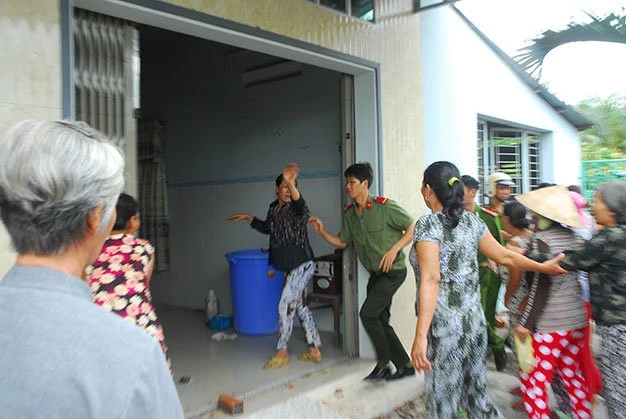 Lực lượng chức năng túc trực để ngăn cản người chơi hụi xông vào nhà bà Tư đòi nợ. Ảnh: Hoài Thương.