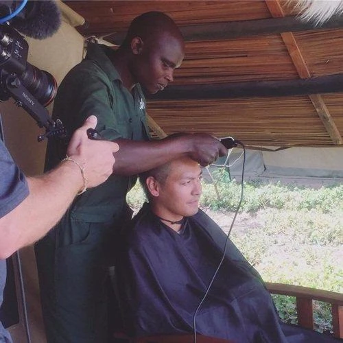 Các nhân viên trong chiến dịch bảo vệ động vật hoang dã tại Châu Phi giúp Phan Anh xuống tóc - Ảnh: NVCC