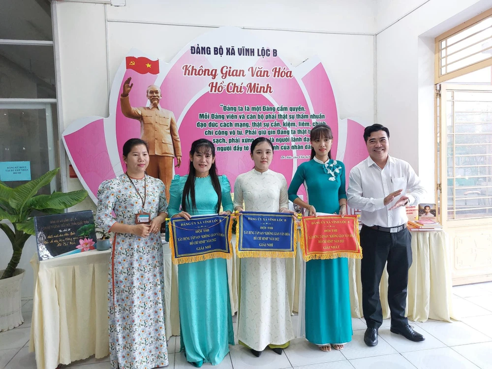 Tại buổi lễ ra mắt, ông Nguyễn Thành Nhân, Bí thư Đảng ủy xã Vĩnh Lộc B (bên phải) và bà Trần Thị Thái Nguyên, Chủ tịch UBND xã trao giải thưởng Hội thi xây dựng tập san “Không gian văn hoá Hồ Chí Minh” cho các đơn vị là các Chi bộ Trường học, các ấp trên địa bàn xã.