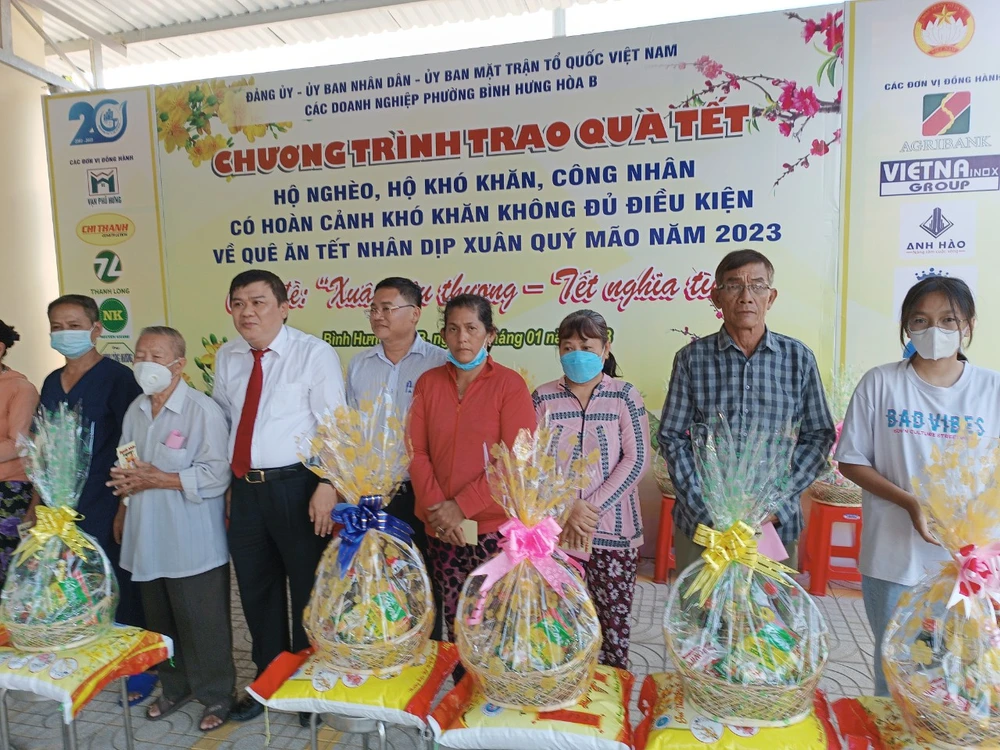 Ông Phạm Hoàng Khanh, Chủ tịch UBND phường Bình Hưng Hòa B cùng đại diện ngân hàng Agribank trao quà cho bà con nghèo