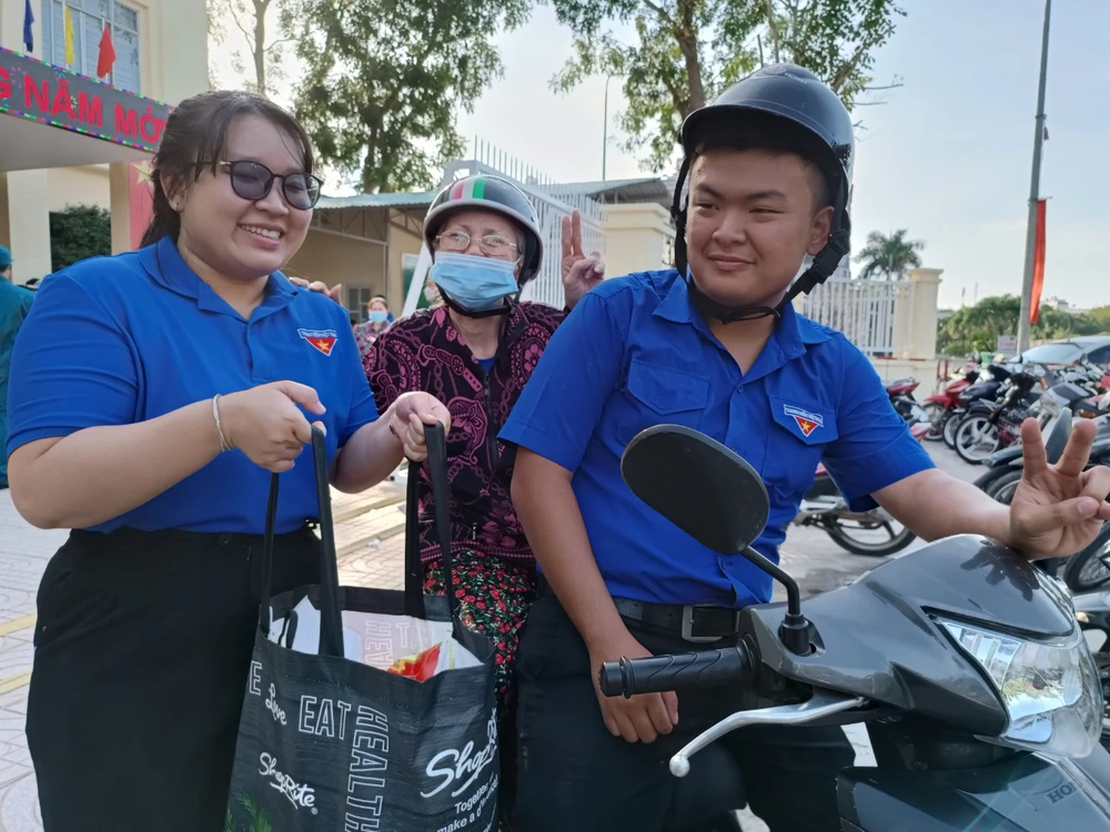 Các bạn đoàn viên hỗ trợ chở cụ Phan Thị Nguyệt, 83 tuổi (khu phố 1) về nhà