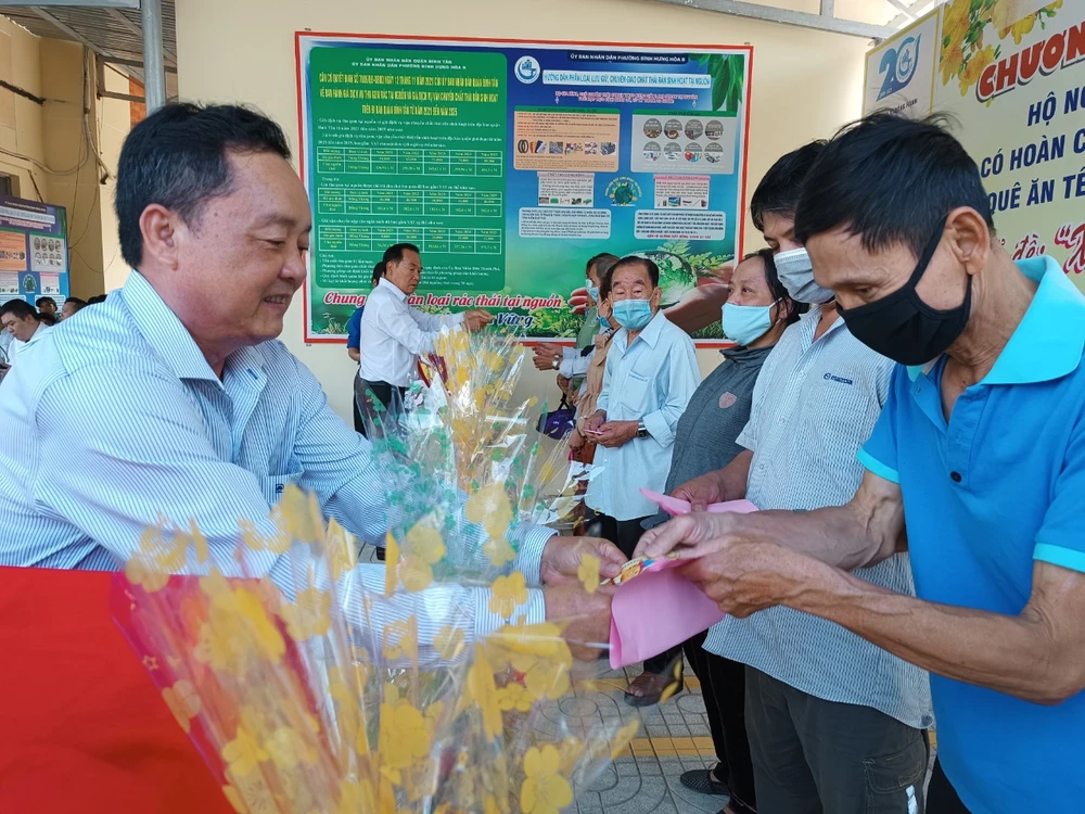 Thiếu tướng Trần Văn Hùng, Nguyên Phó Chính ủy Quân khu 7 trao quà tết cho bà con nghèo, khó khăn ở phường Bình Hưng Hòa B, quận Bình Tân. Ảnh: NGUYỄN TÝ