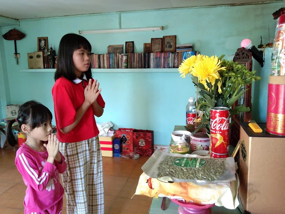 Con cháu cúng bàn thờ gia tiên ngày mùng 1 tết. Ảnh: KIM THỦY