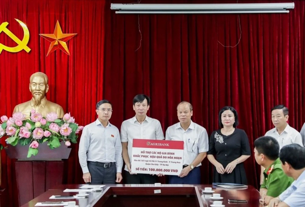 Đại diện Agribank đ/c Phạm Đức Ấn – Bí thư Đảng ủy, Chủ tịch HĐTV (phía ngoài bên trái) và đ/c Phạm Đức Tuấn – Thành viên HĐTV, Chủ tịch Công đoàn Agribank (thứ 2 bên trái) trao hỗ trợ các gia đình khắc phục hậu quả do hỏa hoạn.jpg