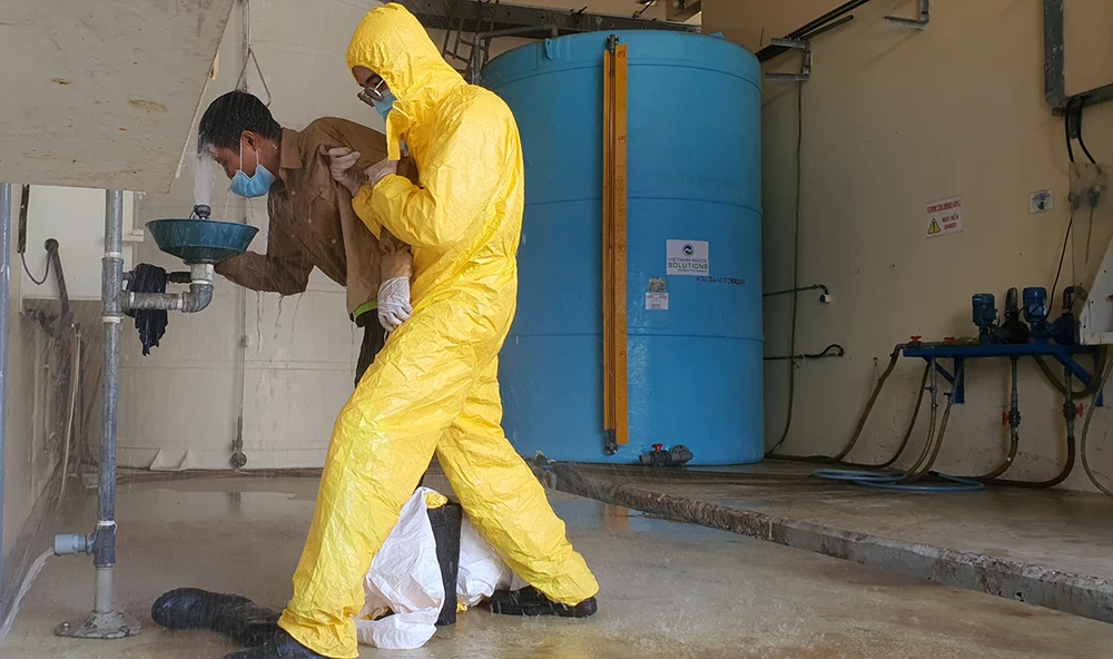 Tình huống giả định người lao động bị sự cố hóa chất đổ vào người đang được dội nước rửa sạch hóa chất trước khi chuyển đi cấp cứu.jpg