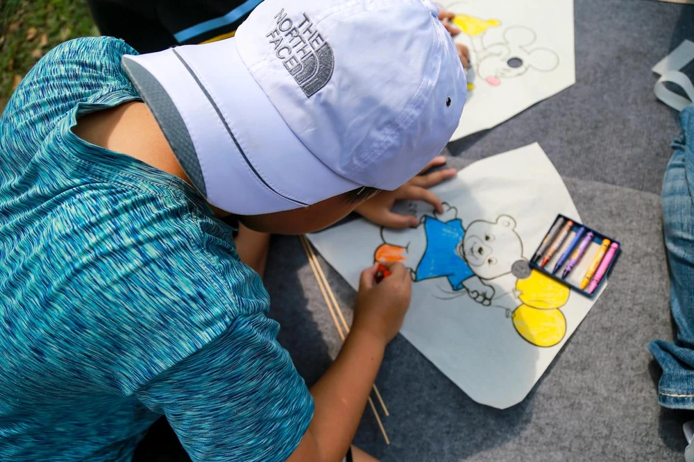 Một em nhỏ trải nghiệm làm diều tại Lễ hội diều Huế. Một em nhỏ trải nghiệm làm diều tại Lễ hội diều Huế.