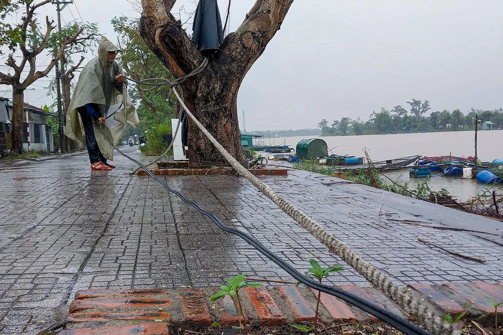Người dân gia cố bằng những sợi dây lớn, tránh để các lồng cá bị nước lũ cuốn trôi.
