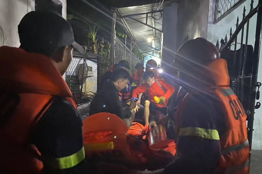 Lực lượng chức năng tiếp cận, ứng cứu người dân khỏi dòng nước lũ.