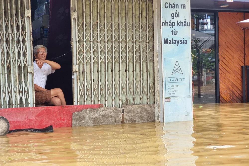 Ông Lại Đăng Khánh ngồi trong căn nhà ngập nước.