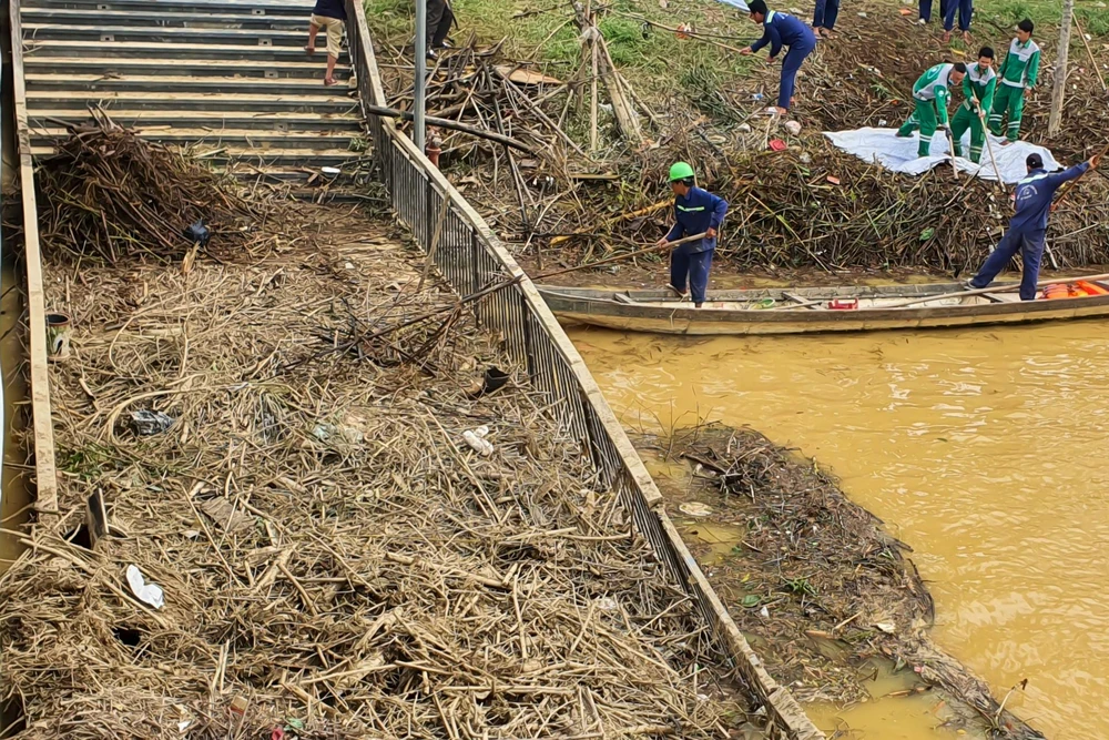 Rác thải chất đầy trên cầu, các công nhân vệ sinh môi trường đang khẩn trương dọn dẹp.