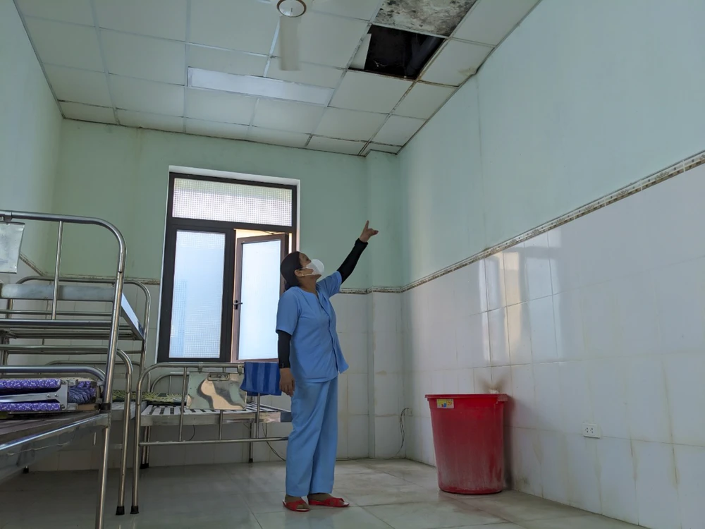 Nhân viên Bệnh viện đa khoa Triệu Phong cơ sở 2 phải dùng chậu hứng nước từ trần nhà. Ảnh: NGUYỄN DO