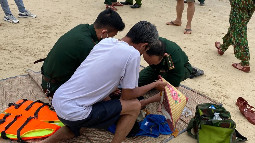 Lực lượng chức năng và người dân sơ cứu người bị đuối nước. Ảnh: PV