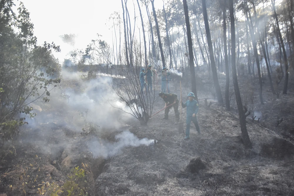 Lực lượng chức năng tham gia dập lửa. Ảnh: NGUYỄN DO