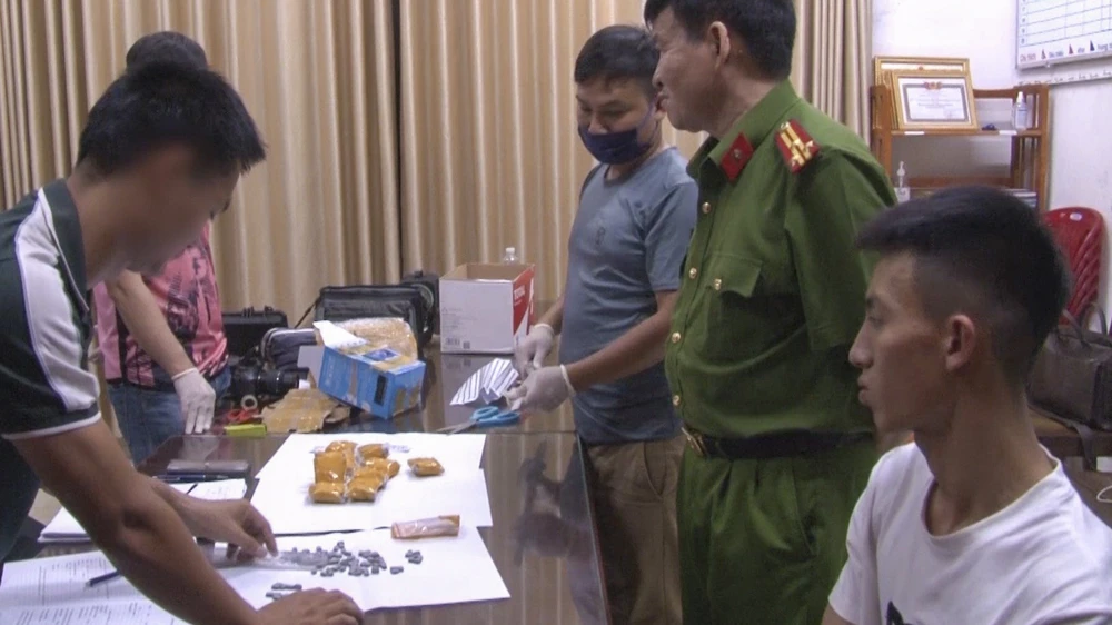 Nguyễn Việt Đức (mặc áo trắng) bị bắt giữ khi vận chuyển hơn 1.000 viên ma túy. Ảnh: C.QUANG