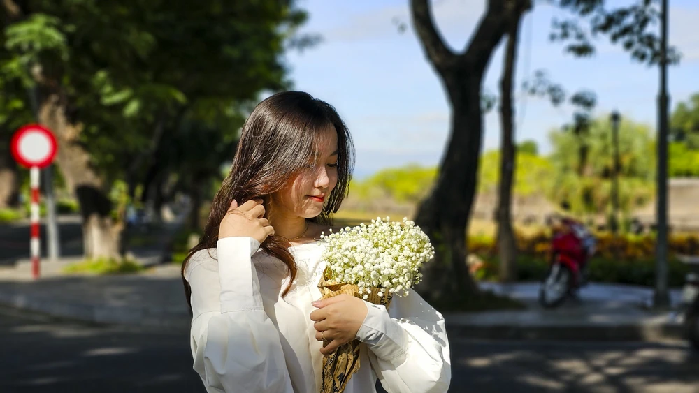 Thiếu nữ khoe sắc bên những bó hoa tươi thắm khi xứ Huế vào thu.