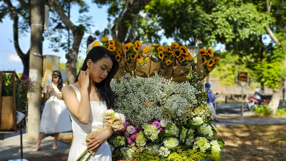 Chiếc xe chở đầy hoa hợp với khung cảnh thơ mộng của xứ Huế.