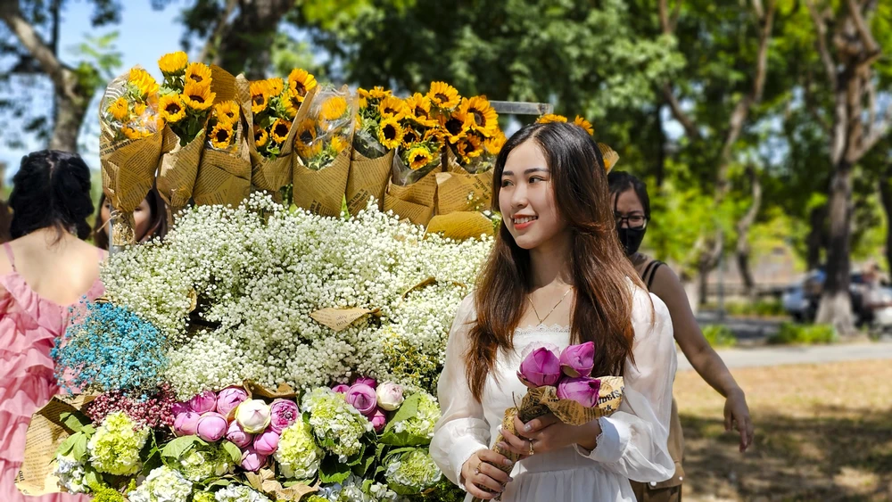 Những chiếc xe chở đầy các loài hoa khác nhau nổi bật bên hè phố.