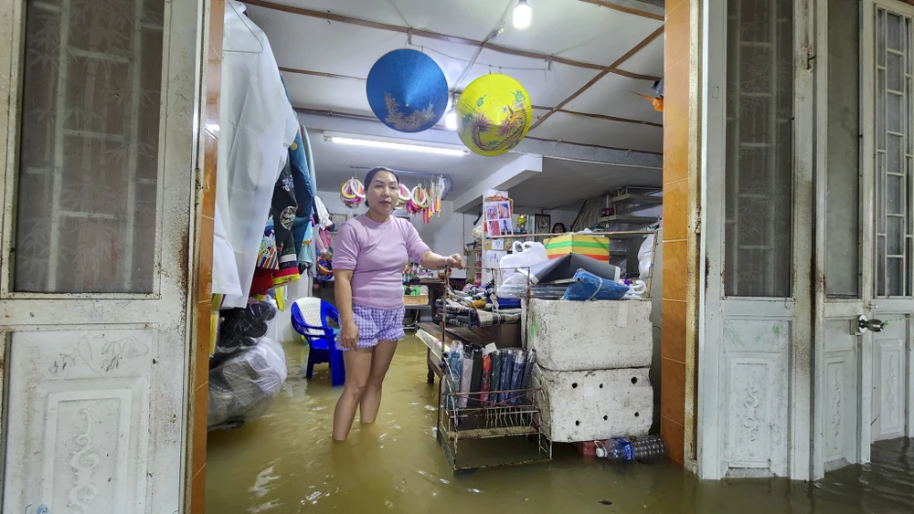 Chị Quỳnh Anh cùng đưa tranh thủ thời gian đưa đồ đạc lên cao. Ảnh: NGUYỄN DO