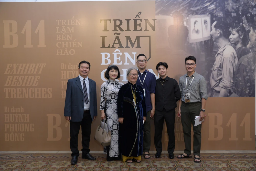 Hoàng Việt (giữa) và Hùng Cường (bên phải ngoài cùng) cùng gia đình hoạ sĩ Huỳnh Phương Đông tại buổi triển lãm. Ảnh: BTC.