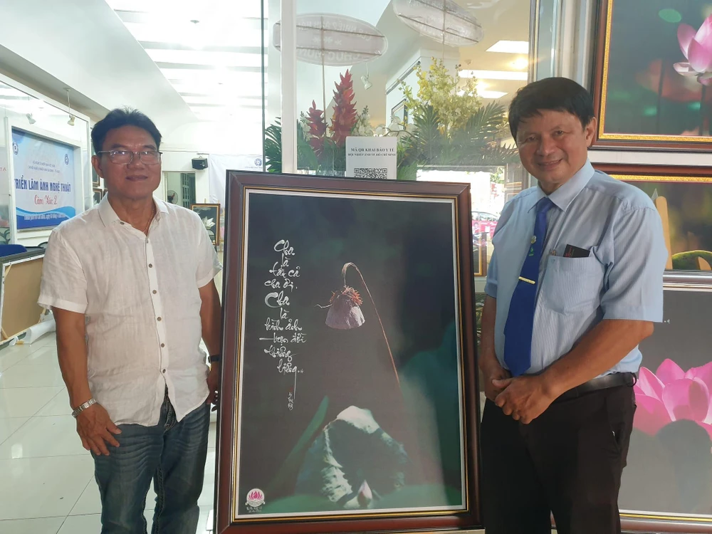 Nhiếp ảnh gia Thành Xuân Anh (trái) và nhiếp ảnh gia Đoàn Hoài Trung - Chủ tịch Hội Nhiếp ảnh TP.HCM. Ảnh: VĂN HÀ.