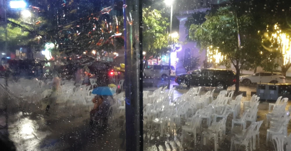 Nhiều khán giả vẫn che ô ở lại theo dõi các nghệ sĩ biểu diễn. Ảnh: V.H