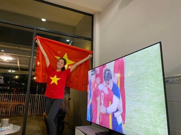 Xem bóng đá tại nhà, hoa hậu Khánh Vân vẫn "bày biện" ảnh cầm cờ Việt Nam đứng cạnh màn hình TV đang phát cảnh các cầu thủ ăn mừng. "Việt Nam chiến thắng, Việt Nam vô địch. Tự hào Việt Nam ơi" - Khánh Vân hào hứng. Ảnh: FBNV.