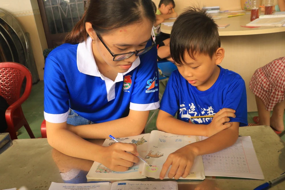 Thảo Nhi dạy một em nhỏ cách phát âm. Ảnh: VÕ THƠ.