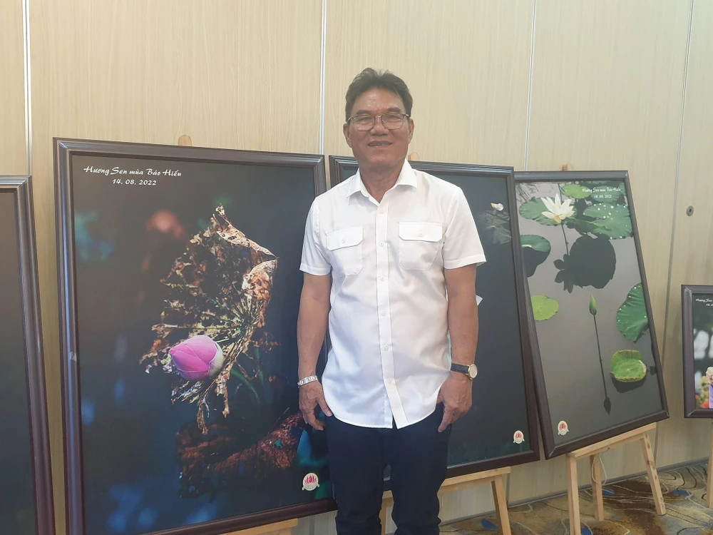 Nhiếp ảnh gia Thành Xuân Anh bên cạnh các tác phẩm Sen. Ảnh: HÀ NGUYỄN.