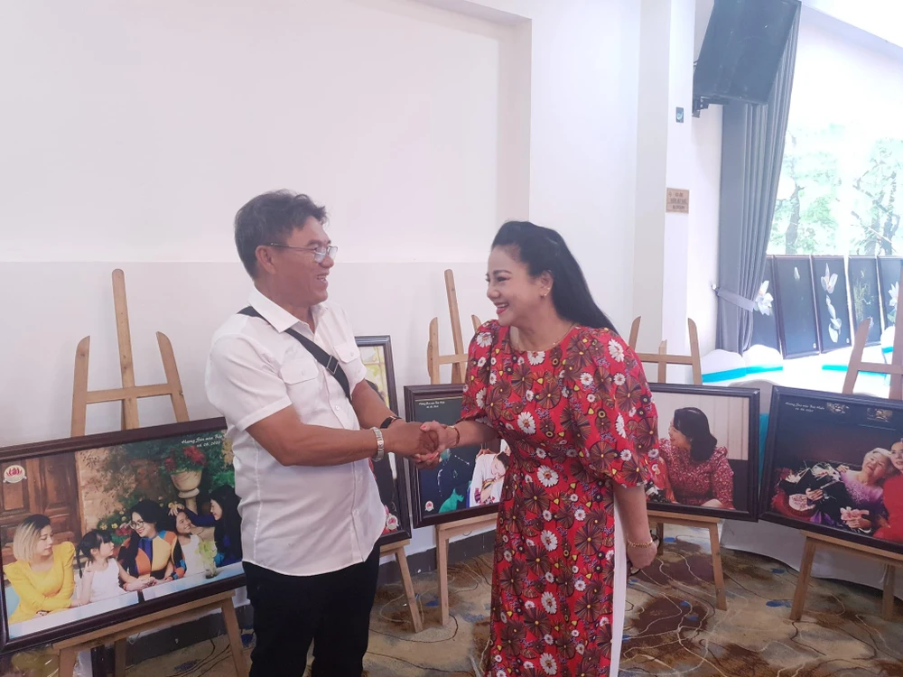 Nhiếp ảnh gia Thành Xuân Anh và nữ ca sĩ Ngọc Ánh tại buổi triển lãm. Ảnh: HÀ NGUYỄN.